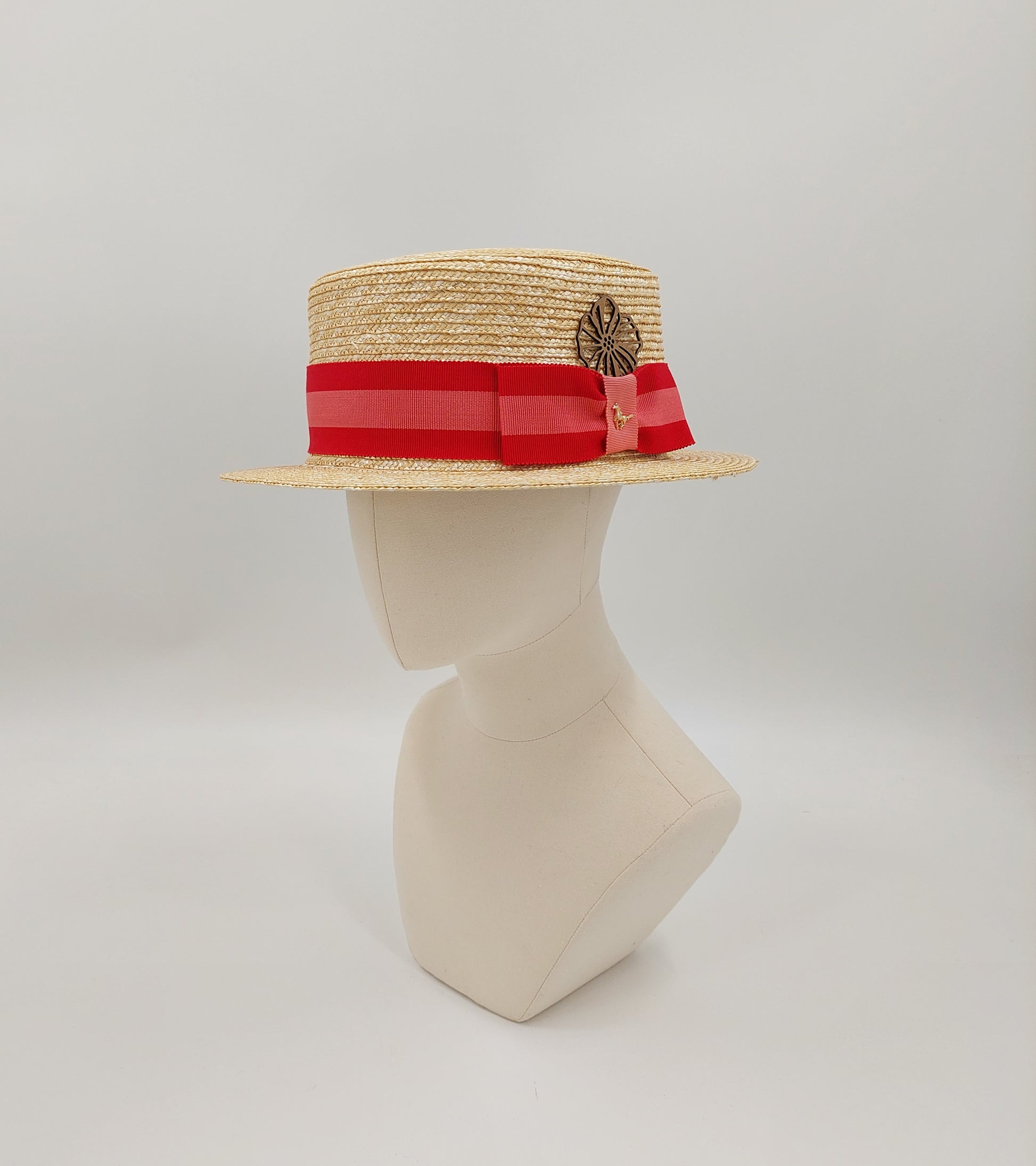 Men's boater in natural toyo straw. Finished with a grey and coral petersham ribbon imported from England. Accented with a gold horse pin. 57cm.