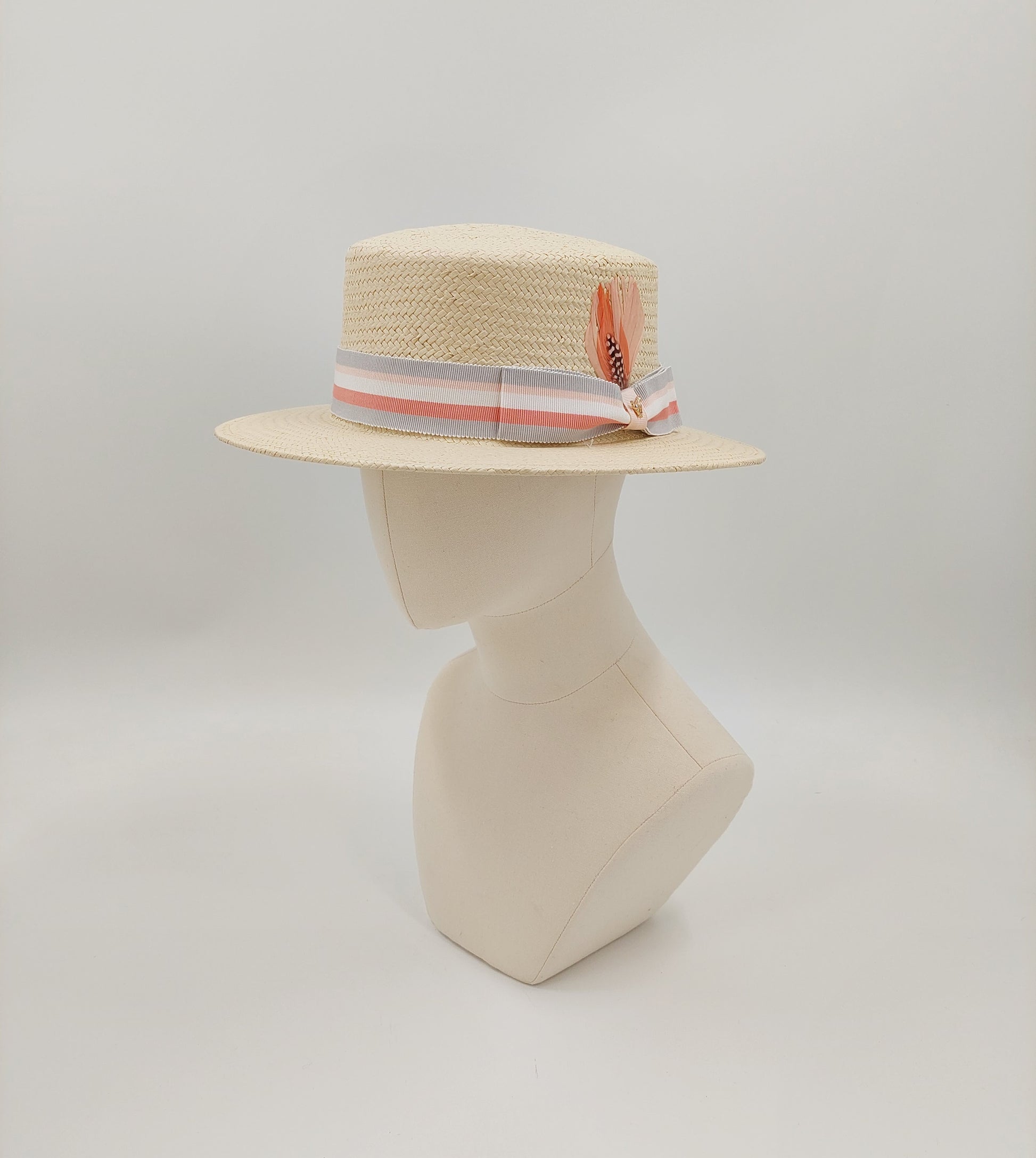 Men's boater in natural toyo straw. Finished with a grey and coral petersham ribbon imported from England. Accented with a gold horse pin. 57cm.